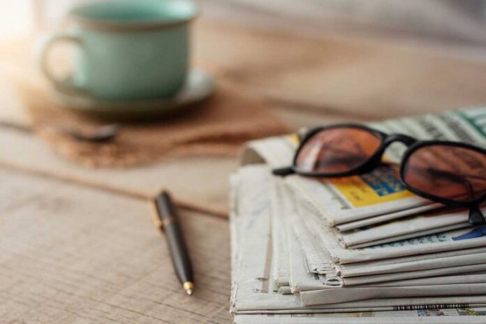 Newspapers and glasses on the desk.